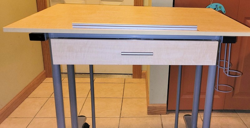Drafting table, slightly used. Steel frame, laminate wood tabletop with drawer