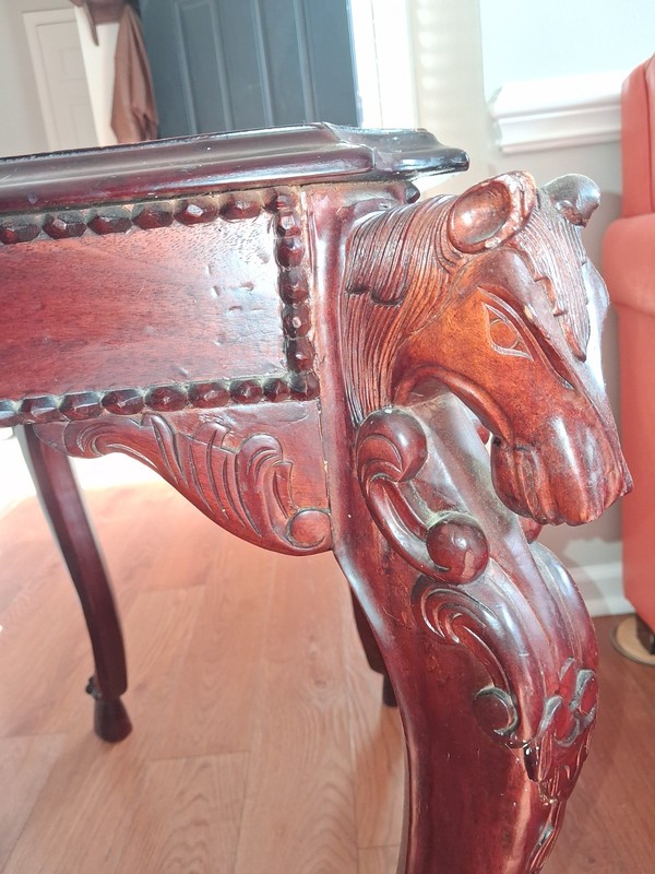 Hand-carved mahogany side table featuring horse head details and hoofed feet.