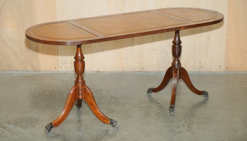 VINTAGE HAND DYED AND AGED BROWN LEATHER OVAL COFFEE TABLE WITH LION CASTORS gallery