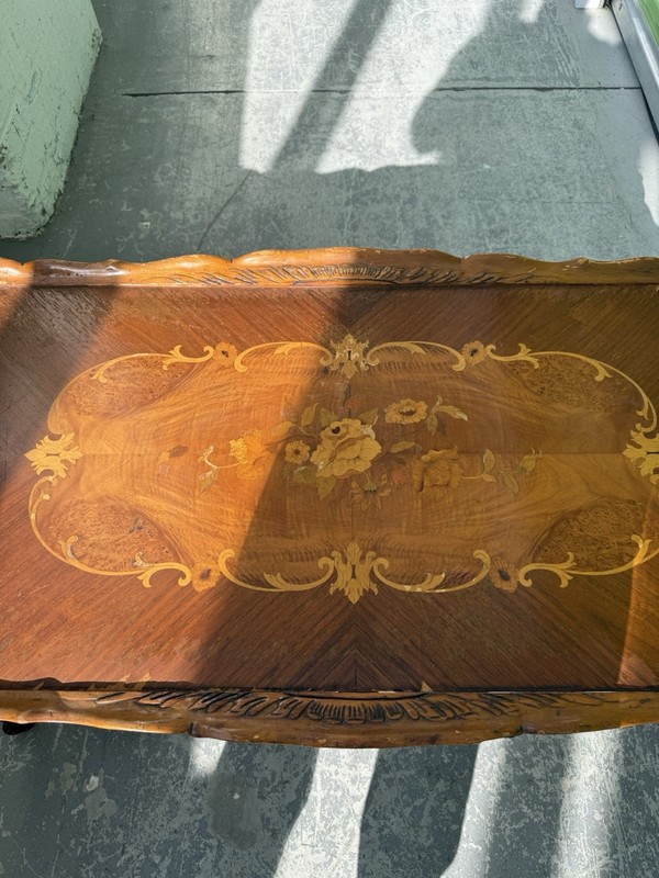 Walnut coffee table with satinwood marquetry inlay and hand-carved cherub. gallery