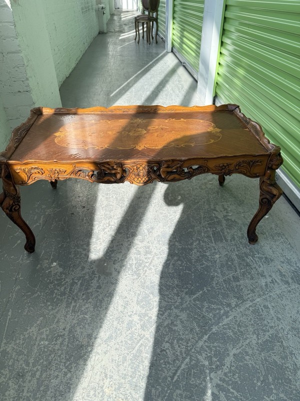 Walnut coffee table with satinwood marquetry inlay and hand-carved cherub.