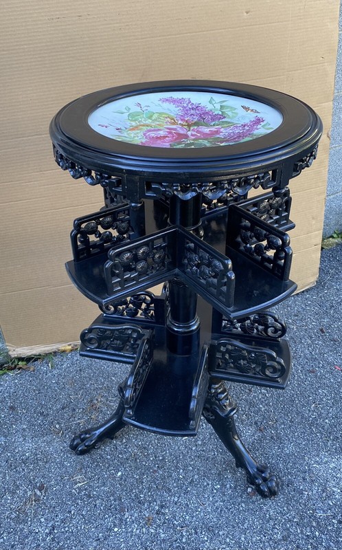 BLACK LACQUERED REVOLVING BOOKSTAND WITH PAINTED PORCELAIN TOP