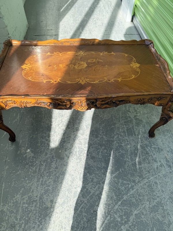 Walnut coffee table with satinwood marquetry inlay and hand-carved cherub. gallery